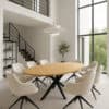 Design eettafel met ovaal houten blad en zwarte metalen spin poot – inclusief beige draaistoelen – modern interieur